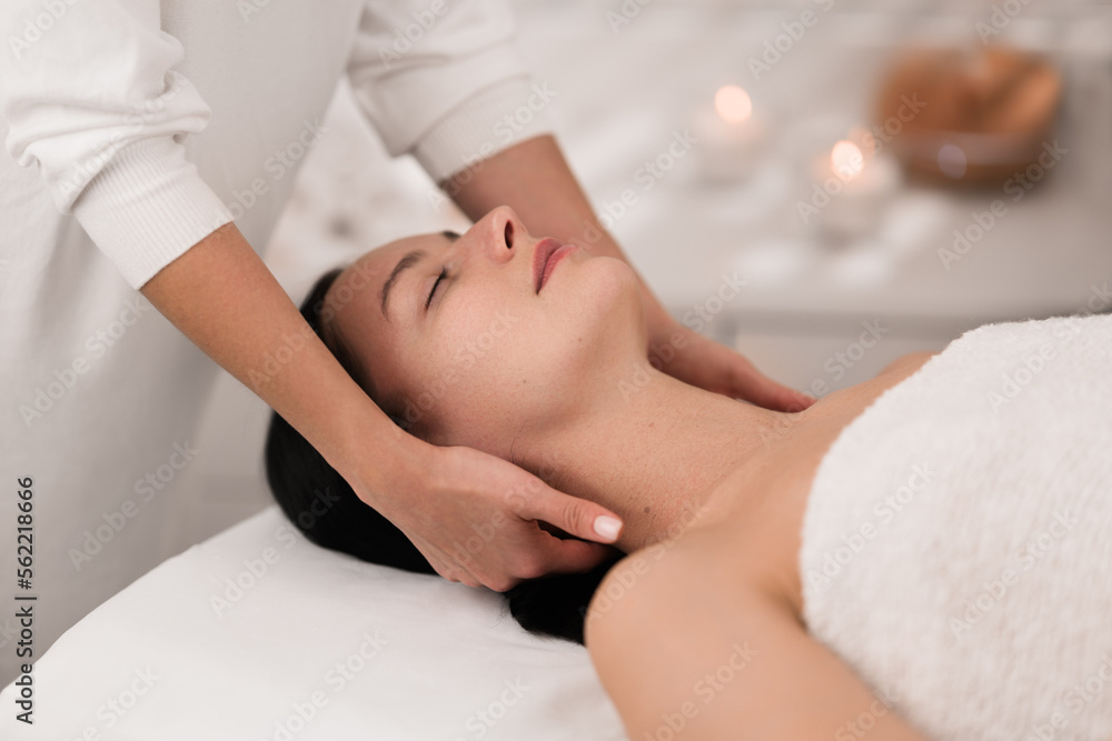 Fototapeta premium Young calm lady relaxing with closed eyes during massage
