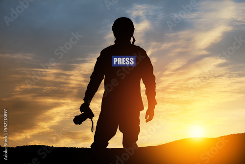 Quadro su tela Photojournalist silhouette documenting war or conflict