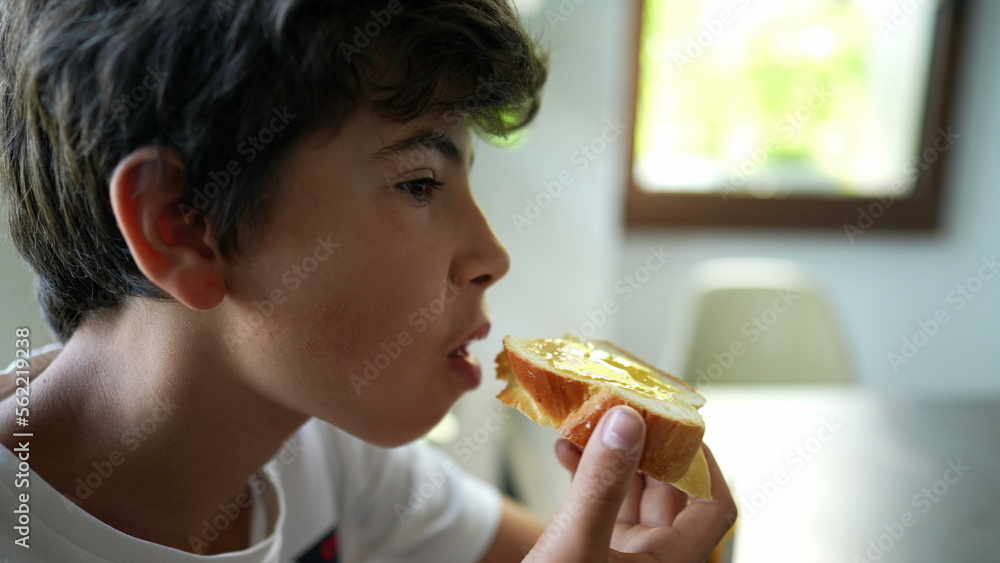 Young boy eating bread with jelly in morning breakfast Young boy eating bread with jelly in morning breakfast