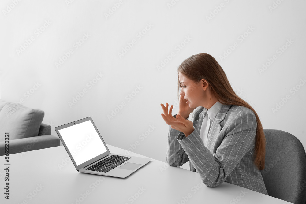 Stressed young businesswoman video chatting with psychologist on laptop in office Stressed young businesswoman video chatting with psychologist on laptop in office