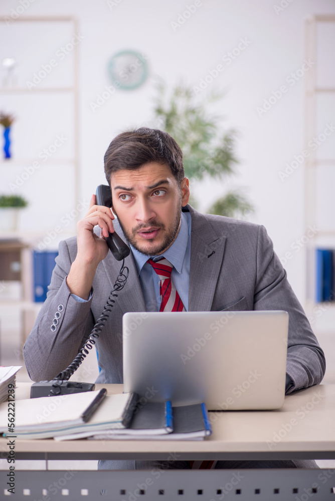 Young male employee working in the office Young male employee working in the office