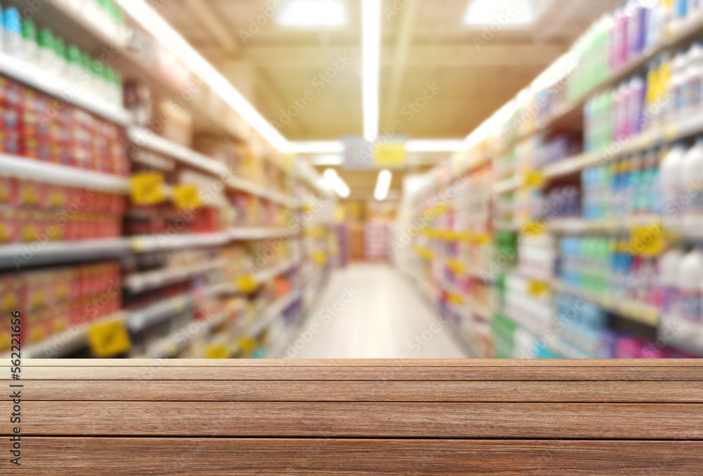 blur aisle image in the supermarket and wooden table