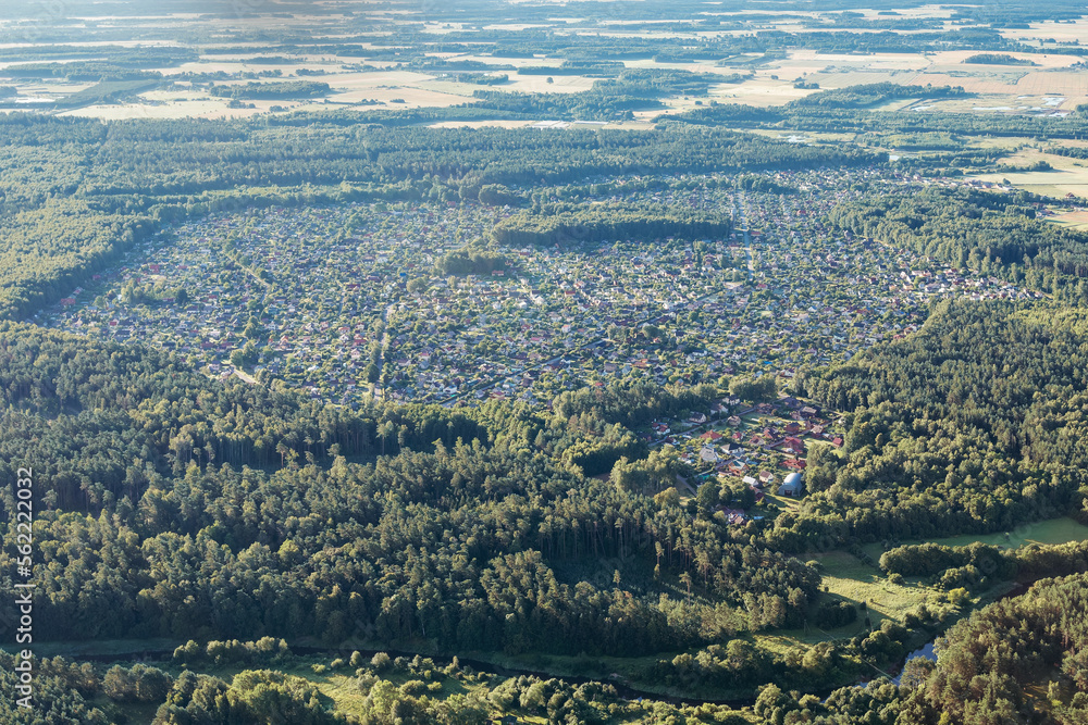A large settlement with small houses in the middle of the forest, view from above