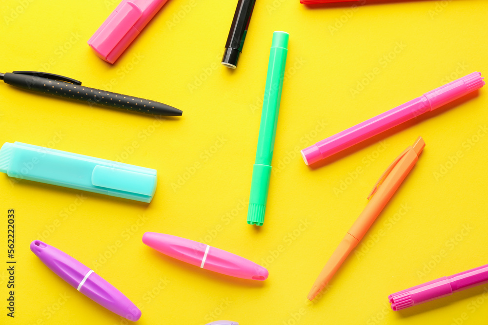 Set of different markers and pens on yellow background Set of different markers and pens on yellow background