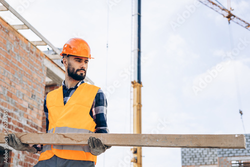 Foreman working on building object holding wooden stick