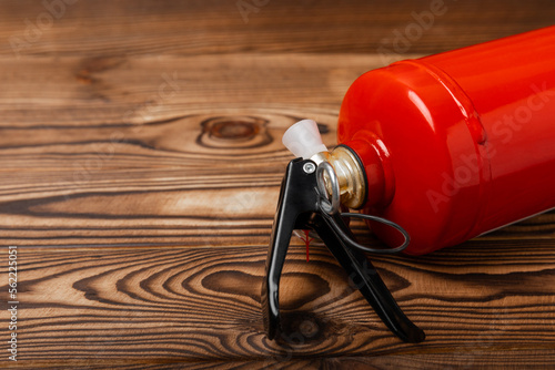 Fire extinguisher on brown wood background. Fire protection, home fire extinguisher. home security concept. Place for text. Copy space. photo