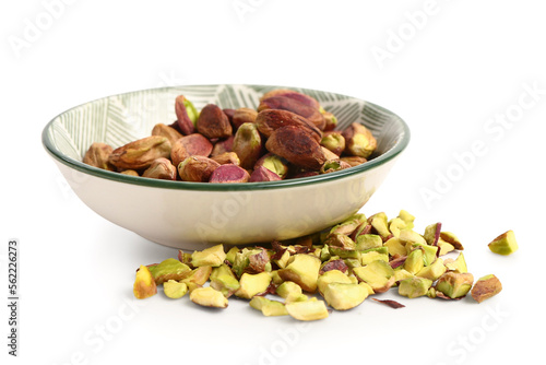 Bowl with peeled and sliced pistachios isolated on white background