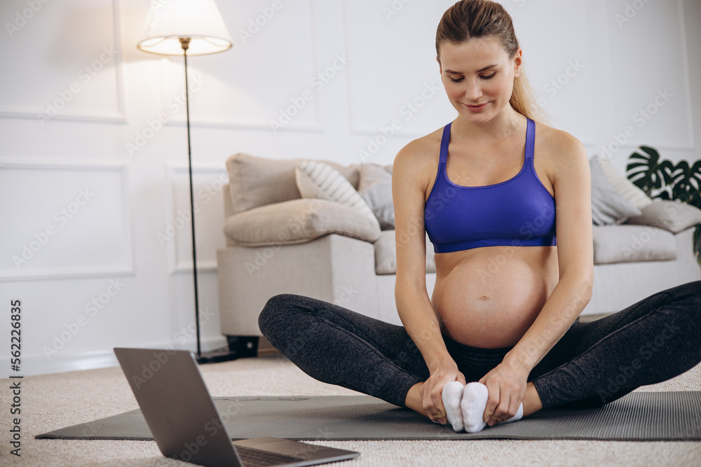 Pregnant woman practicing yoga at home
