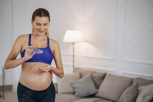 Pregnant woman using stretch mark oil