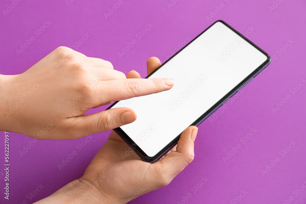 Female hands with modern mobile phone on purple background, closeup Female hands with modern mobile phone on purple background, closeup