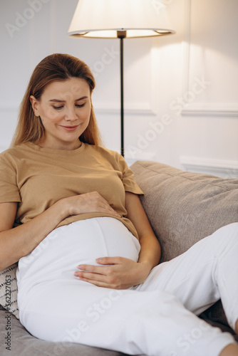 Pregnant woman sitting on the sofa at home