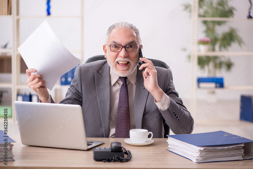 Old male employee working in the office Old male employee working in the office