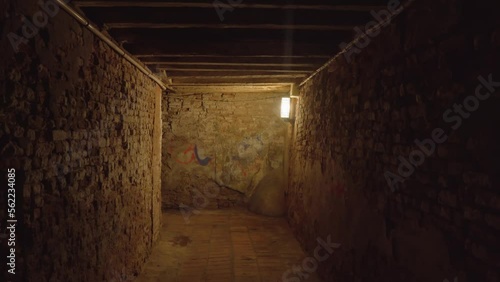 Ancient dark old Venetian passageway with bright lamp illuminating way as interesting attraction for tourists in Venice Italy