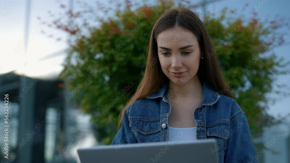 Caucasian female student with laptop outdoors. Young woman using laptop for preparing for exams. Technology, education and remote working concept Caucasian female student with laptop outdoors. Young woman using laptop for preparing for exams. Technology, education and remote working concept