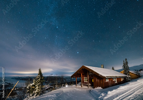 Milky Way stars under Cabin House in Norway. Christmas Night with Snow House Hytte photo