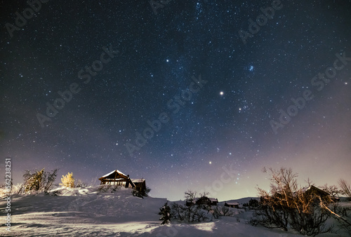 Milky Way stars under Cabin House in Norway. Christmas Night with Snow House Hytte photo