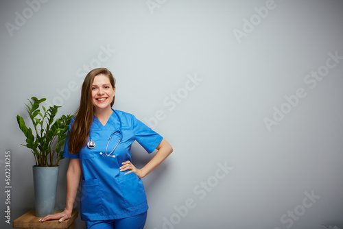 Smiling doctor phyto therapist woman standing near plant. Isolated portrait of female medical worker. photo