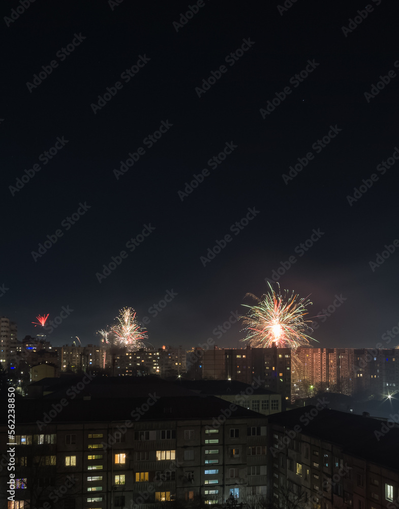 Bright colorful and multi-colored fireworks on New Year's Eve over the city, fireworks explode over a residential city