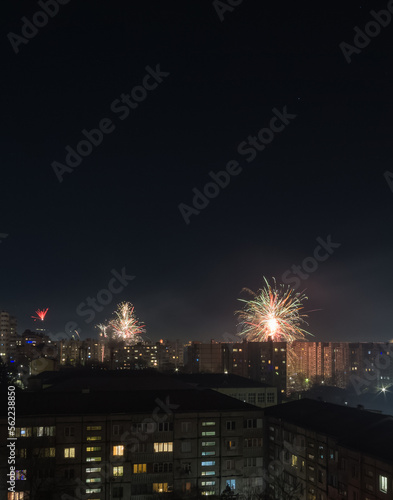 Bright colorful and multi-colored fireworks on New Year s Eve over the city  fireworks explode over a residential city