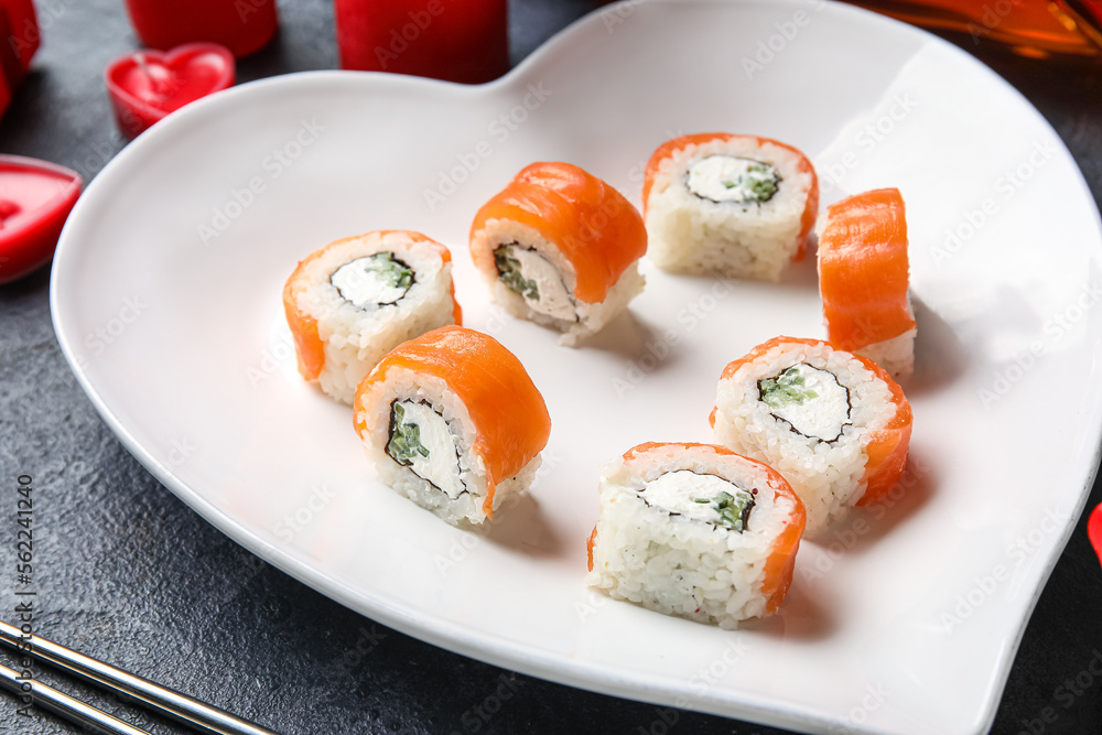 Plate with sushi rolls on dark background, closeup. Valentine's Day celebration