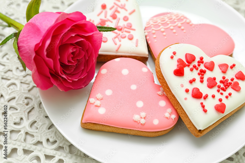 Plate of tasty heart shaped cookies and rose flower, closeup. Valentine's Day celebration Plate of tasty heart shaped cookies and rose flower, closeup. Valentine's Day celebration