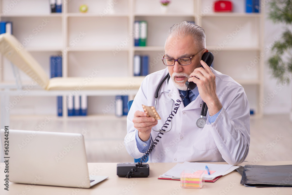 Old male doctor working in the clinic Old male doctor working in the clinic