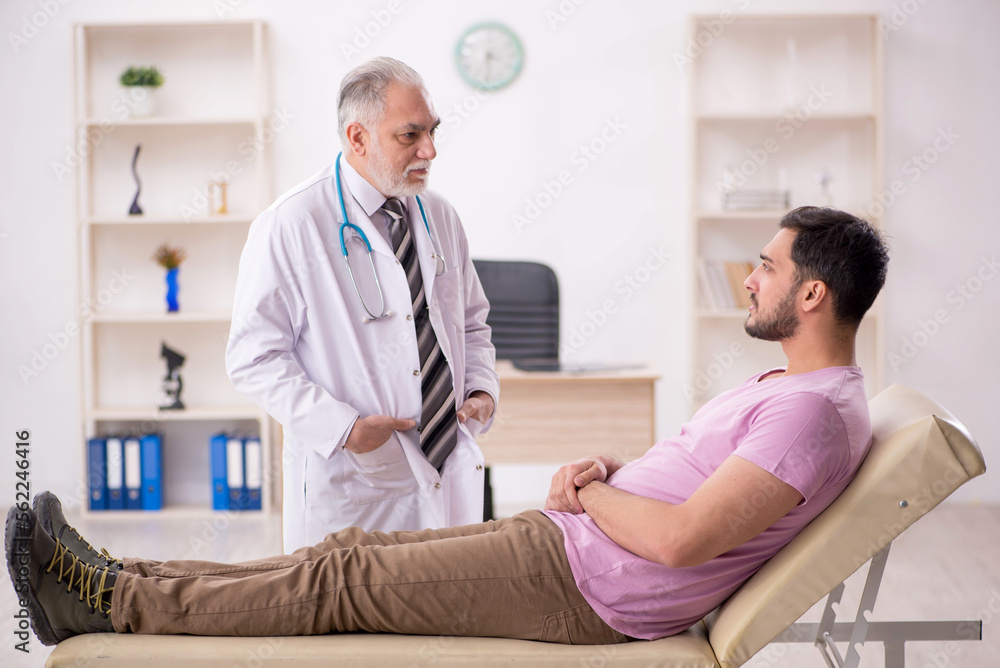 Fototapeta premium Young male patient visiting old male doctor