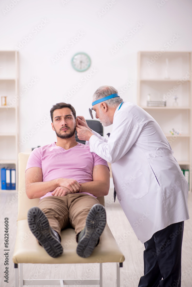 Fototapeta premium Young male patient visiting old male doctor otologist