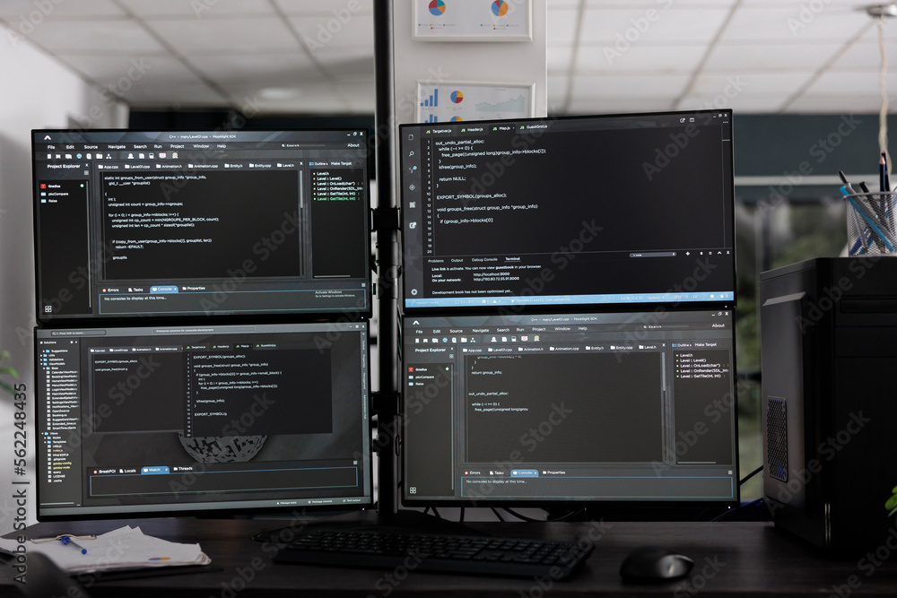 Computer monitors on desk compiling programming html data algorithms in empty software company. Database network servers cloud computing in it agency room, code script language.