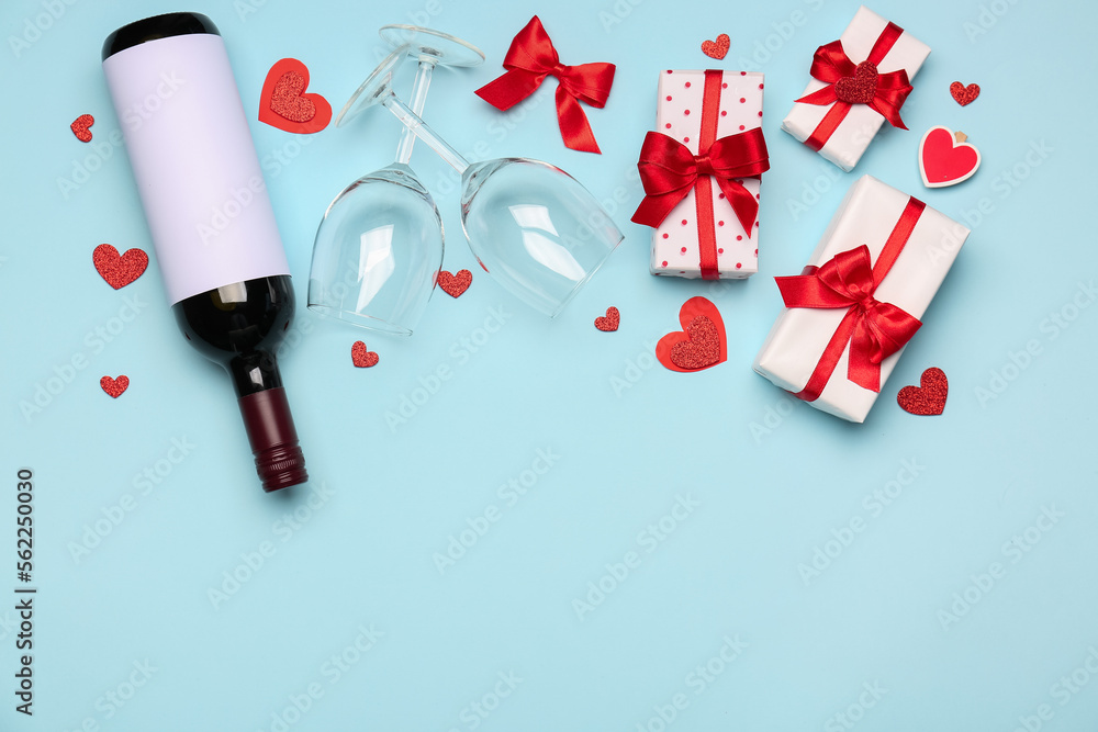 Bottle of wine, glasses and gifts on blue background. Valentine&rsquo;s Day