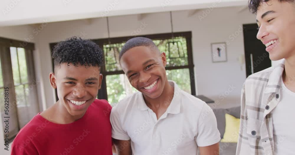 Portrait of happy diverse male teenage friends embracing at home, slow motion Portrait of happy diverse male teenage friends embracing at home, slow motion