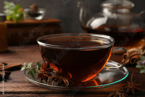 Aromatic tea with anise stars and mint on wooden table, closeup