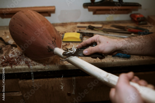 instrument (baglama) master is doing his instrument . instrument and workers hands close-up . selective focus. photo