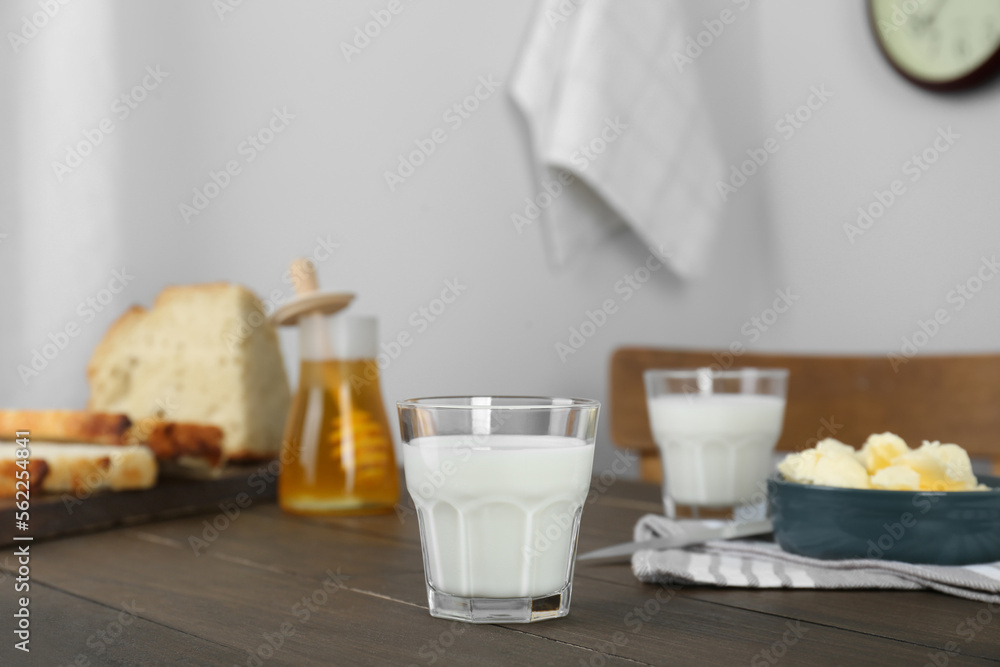 Delicious milk, honey, butter and bread served for breakfast on wooden table Delicious milk, honey, butter and bread served for breakfast on wooden table