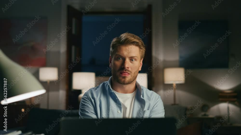 Confused man videocalling apartments closeup. Surprised guy talking online Confused man videocalling apartments closeup. Surprised guy talking online
