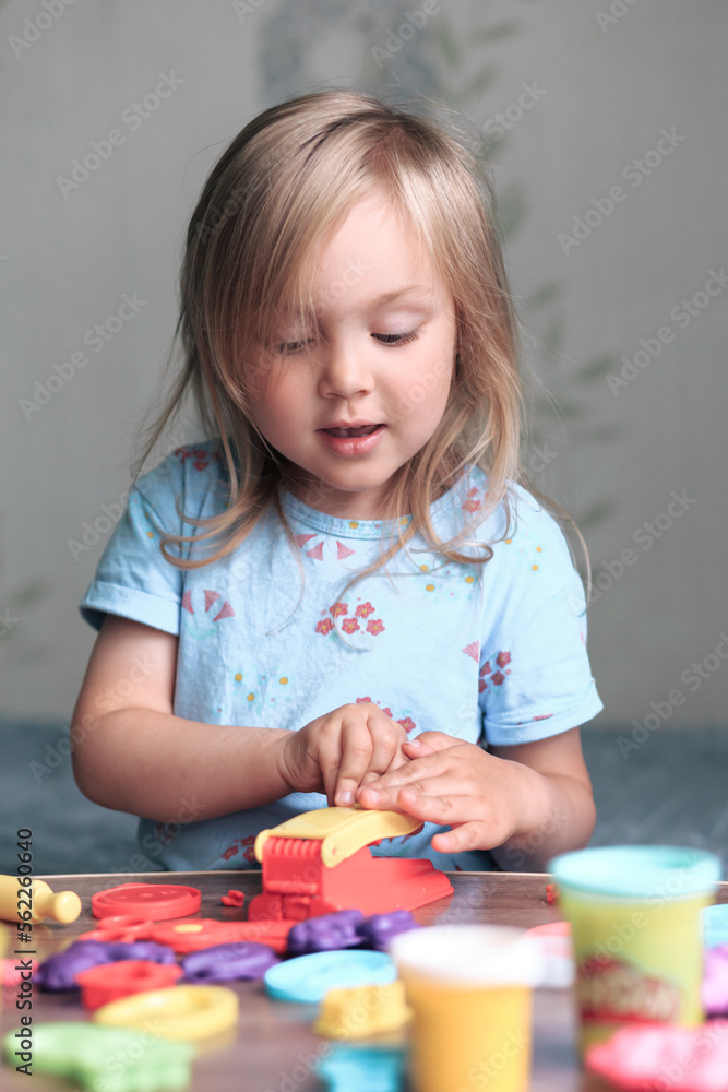 A three-year-old girl sculpts various toys from plasticine, children's games. A three-year-old girl sculpts various toys from plasticine, children's games.