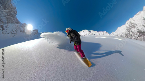 Vászonkép PORTRAIT, SELFIE: Smiling young lady spraying cloud of snow while snowboarding