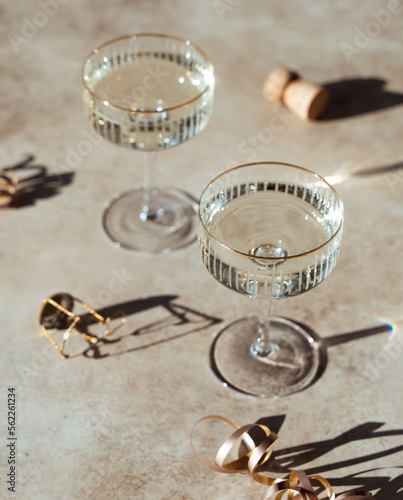 Close up of two glasses of champagne on sunny beige background.