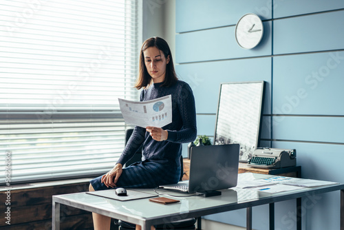 Woman in the office reads a financial report.