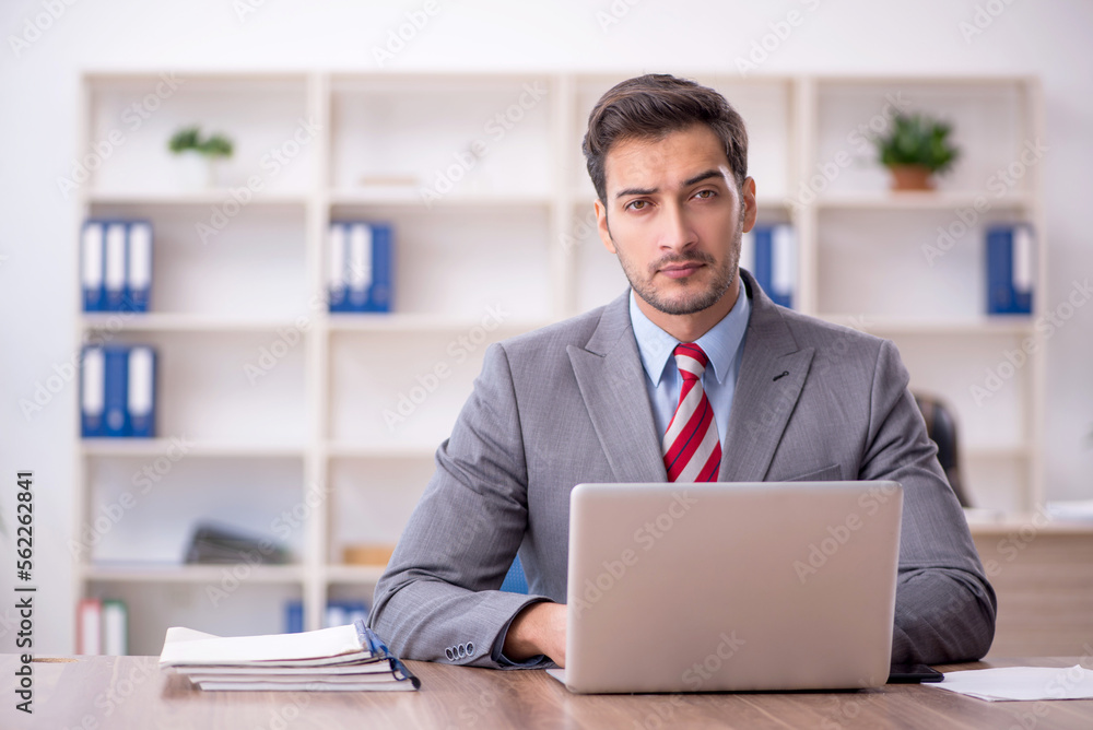 Young male employee working in the office Young male employee working in the office