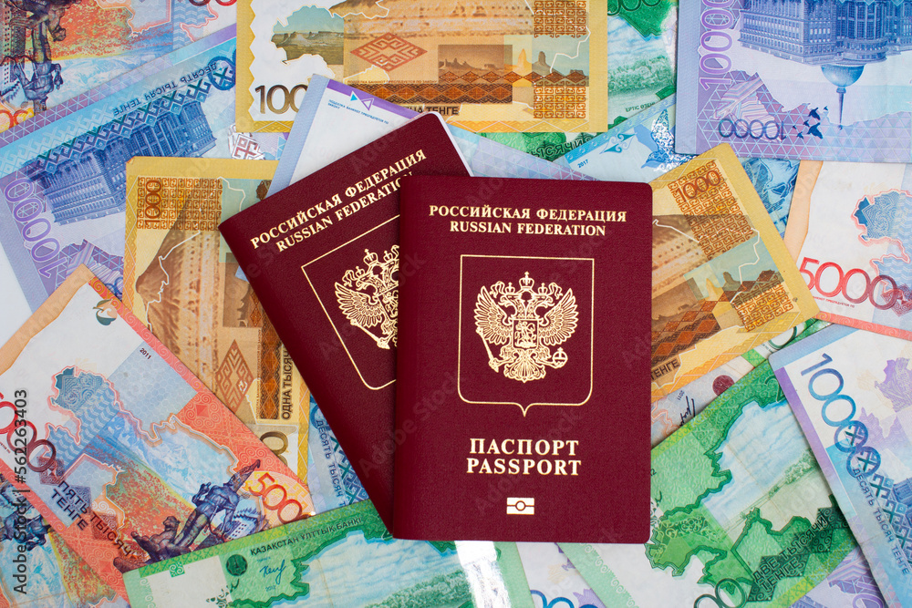 Top view. Red biometric Russian passport. Paper cash banknotes of the Republic of Kazakhstan. Concept of moving, relocation, immigration, buying citizenship, tourism. Currency exchange. Money for pay Top view. Red biometric Russian passport. Paper cash banknotes of the Republic of Kazakhstan. Concept of moving, relocation, immigration, buying citizenship, tourism. Currency exchange. Money for pay