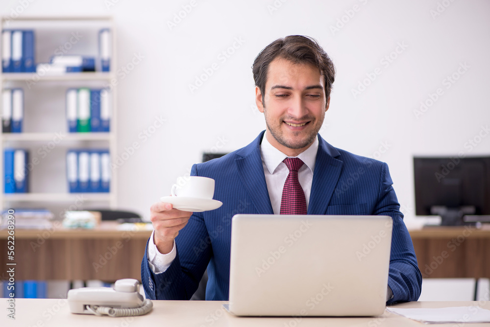 Young male employee drinking coffee during break Young male employee drinking coffee during break