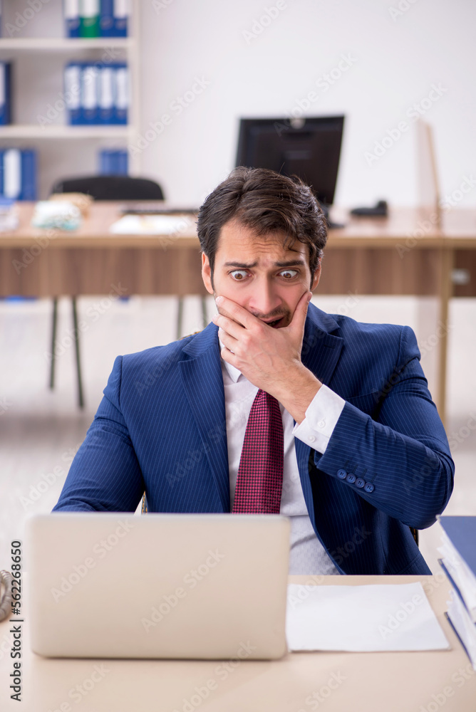 Young male employee working in the office Young male employee working in the office