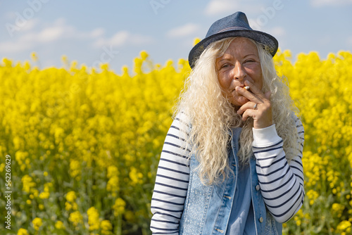 Older casual woman with Hat pulls on cigarette photo