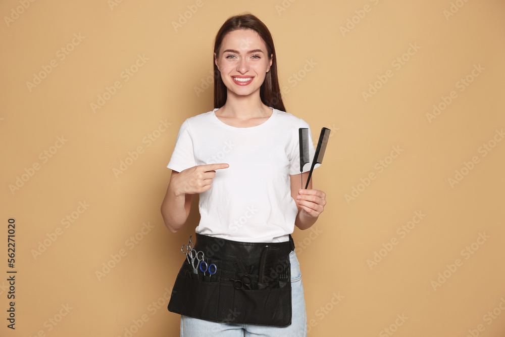 Portrait of happy hairdresser with combs on beige background Portrait of happy hairdresser with combs on beige background