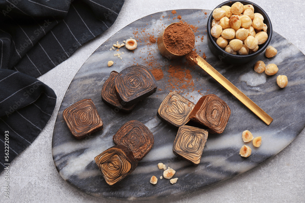 Flat lay composition with tasty chocolate candies and nuts on light grey table Flat lay composition with tasty chocolate candies and nuts on light grey table