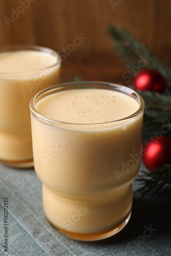 Glasses of delicious eggnog on table, closeup