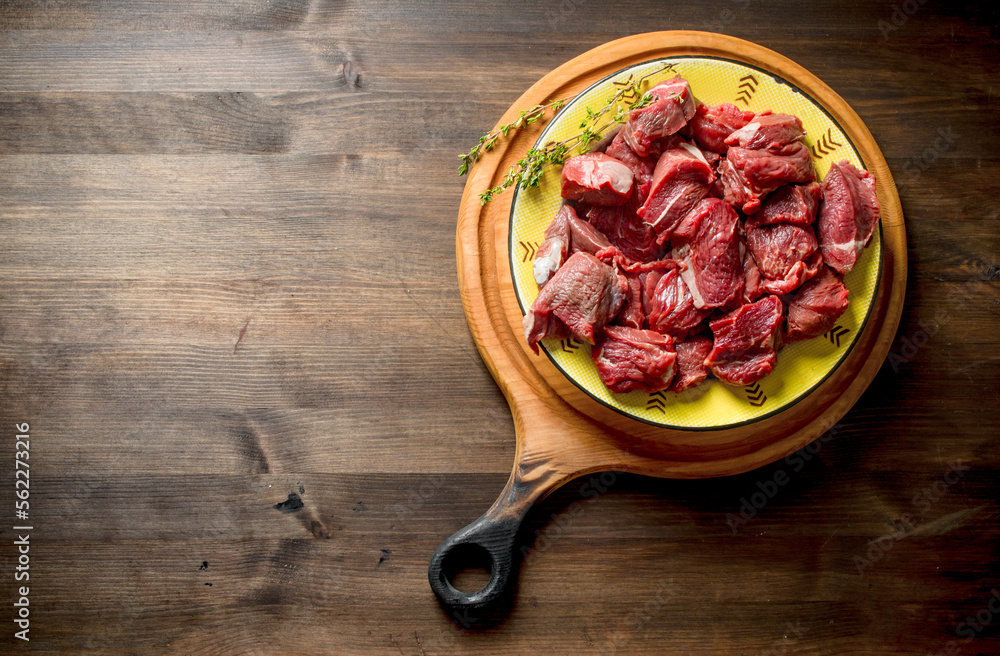 Cut raw beef in a bowl of thyme.