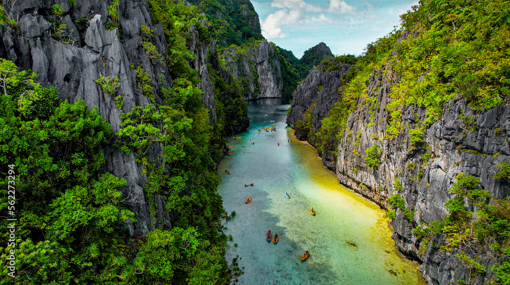 Aerial of Channel in The Big Lagoon In El Nido, Palawan, Philippines. Kayaking In Shallow Crystal Clear Water, Turquoise Colored Reef, Bright Green Tree Covering Cliffs