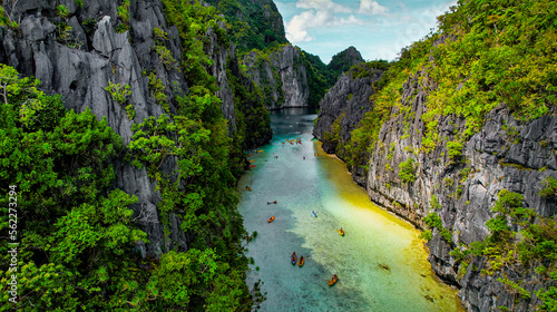 Aerial of Channel in The Big Lagoon In El Nido, Palawan, Philippines. Kayaking In Shallow Crystal Clear Water, Turquoise Colored Reef, Bright Green Tree Covering Cliffs photo
